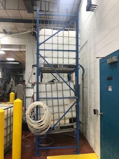 A blue metal rack with white pipes in it.